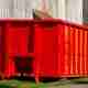 Isolated rugged red industrial dumpster yard